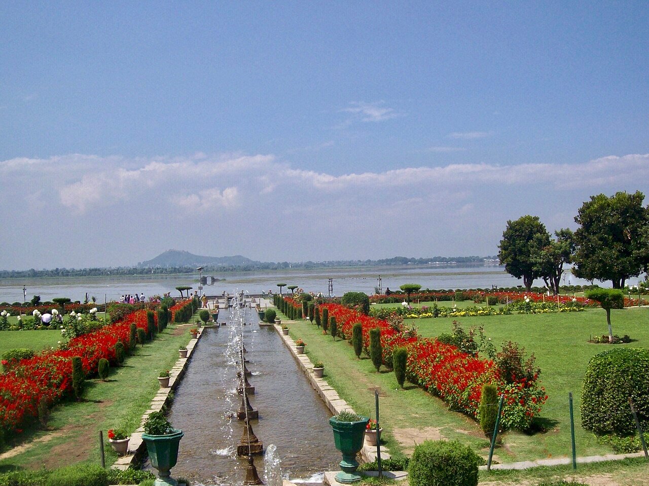 A formal terraced garden with rows of flowerbeds and mountain views