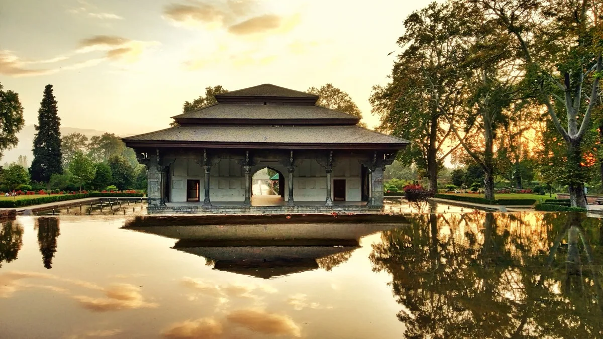 Stone pavilion reflected in a Mughal garden water channel, Srinagar