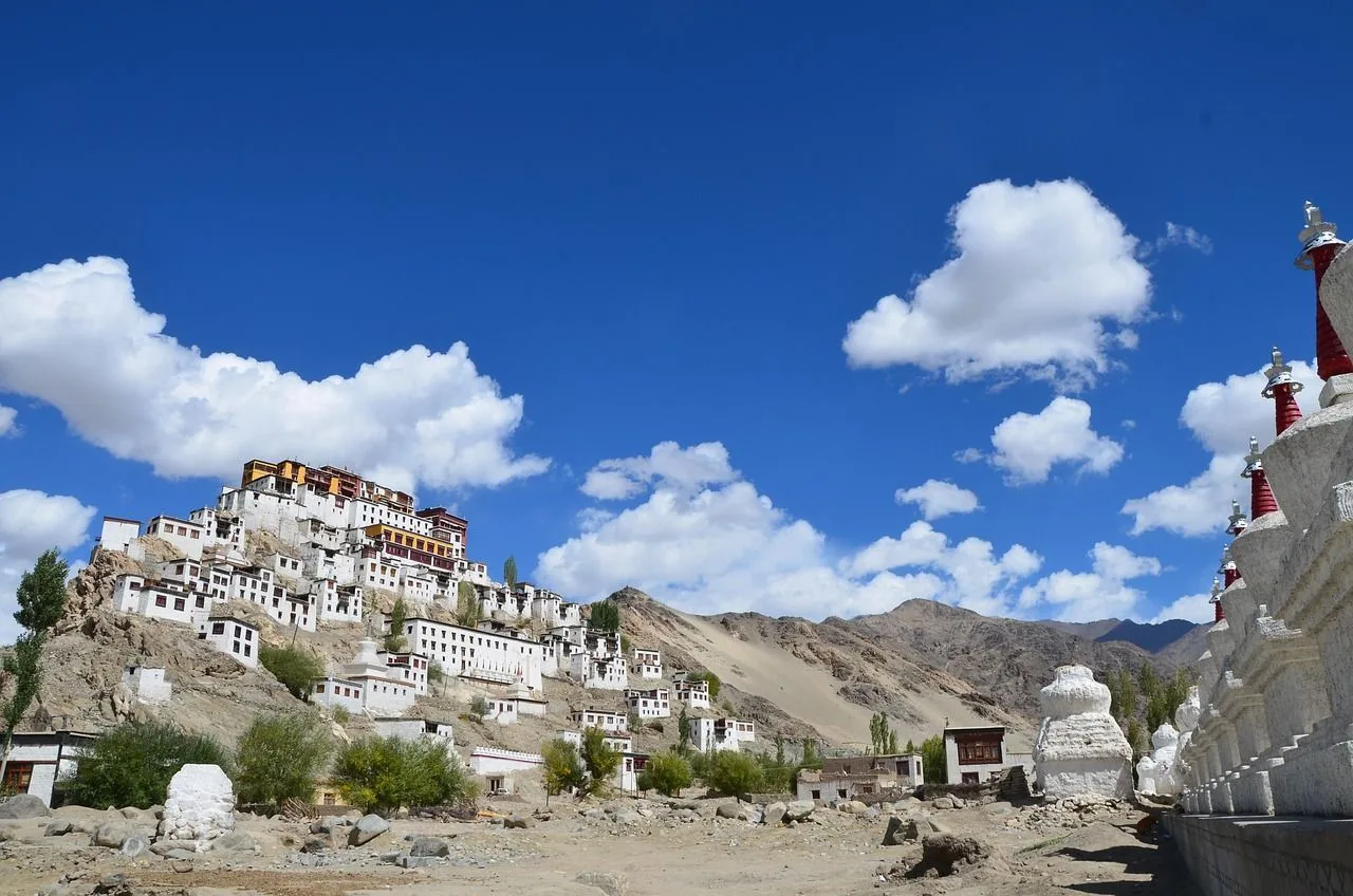Thiksey Monastery rising in white tiers on its hill above a row of chortens, Ladakh